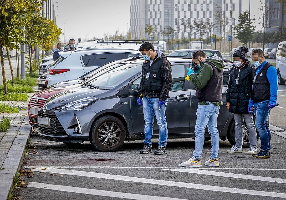 Agentes especializados de la Ertzaintza fotografían un charco de sangre de la víctima, que salió a la calle a pedir ayuda.