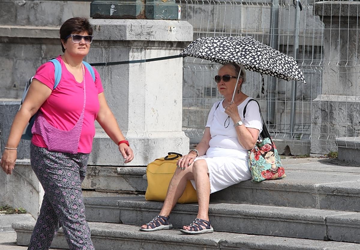 Una mujer se protege del calor con un paraguas en Bilbao.