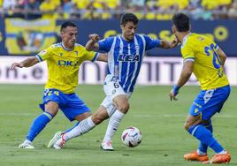 Guevara controla el balón entre dos rivales.