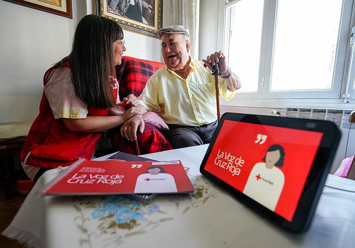 Joaquín Rodríguez ríe junto a Mertxe García, trabajadora social de Cruz Roja, que le suele atender por videoconferencia en el programa Etxean Bai.