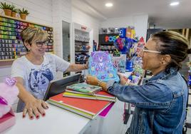 Una mujer compra material escolar en la librería Caype.