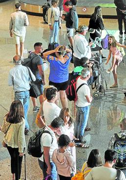 Imagen - Espera. Pasajeros aguardan a que salgan las maletas.