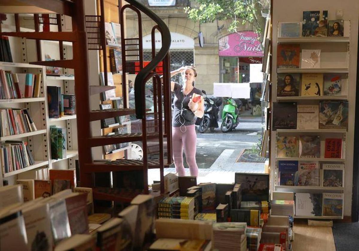 Una paseante curiosea el escaparate de la histórica librería en la calle Urdaneta.