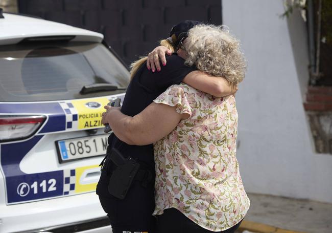 Dos mujeres se abrazan tras el asesinato en Alzira.