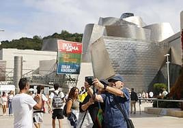 Turistas, delante del Guggenheim, captando imágenes de Puppy.