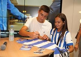 Karrikaburu firma la bandera albiazul a una joven aficionada.