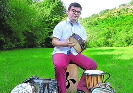 Aitor Aspuru tocando el pandero y rodeado de instrumentos en su casa de Etxegoien.