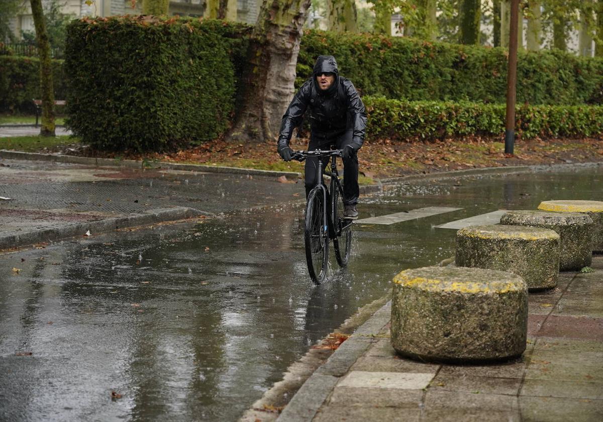 Un ciclista circula por Vitoria bajo la lluvia.