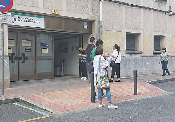 Varias personas esperando para ser atendidos en la puerta de entrada del ambulatorio del barrio baracaldés de San Vicente.