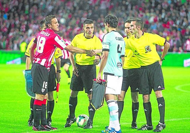 Los capitanes Carlos Gurpegui y Borja Oubiña saludan al equipo arbitral del estreno del nuevo San Mamés, dirigido por Jesús Gil Manzano, entre medias de ambos.