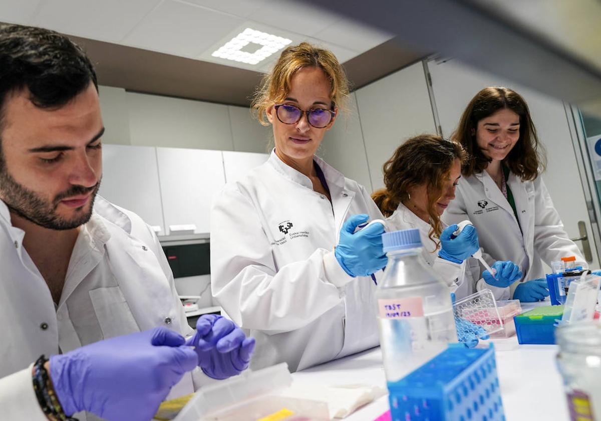 La investigadora Amaia Arranz junto a tres miembros de su equipo en su laboratorio del centro Achucarro para la neurociencia, María Alfonso Triguero, Jon Olalde Jornetón y Leire Ruiz Barreiro.