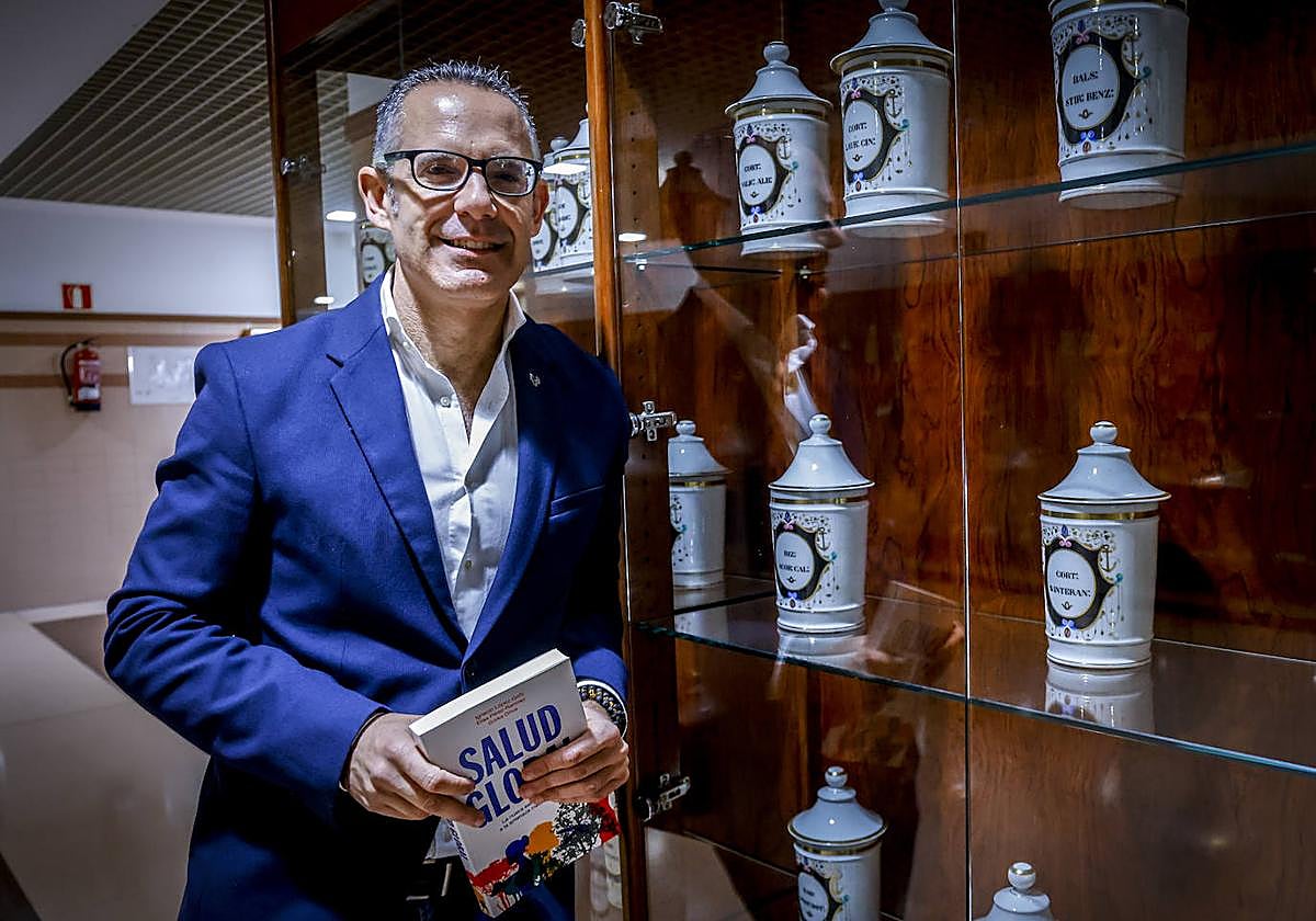 Gorka Orive delante de una vitrina con botes medicinales antiguos.