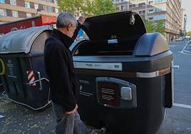 Un hombre deposita la basura en un cotenedor 'marrón' en el barrio de Lakua.