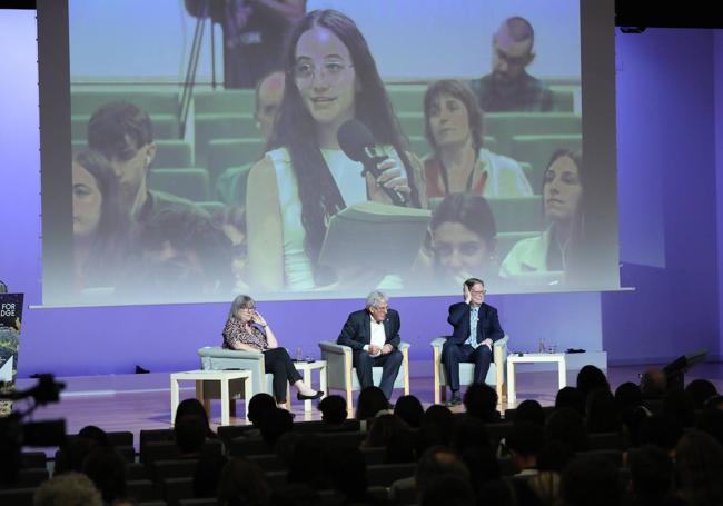 Una estudiante plantea su pregunta a los científicos.