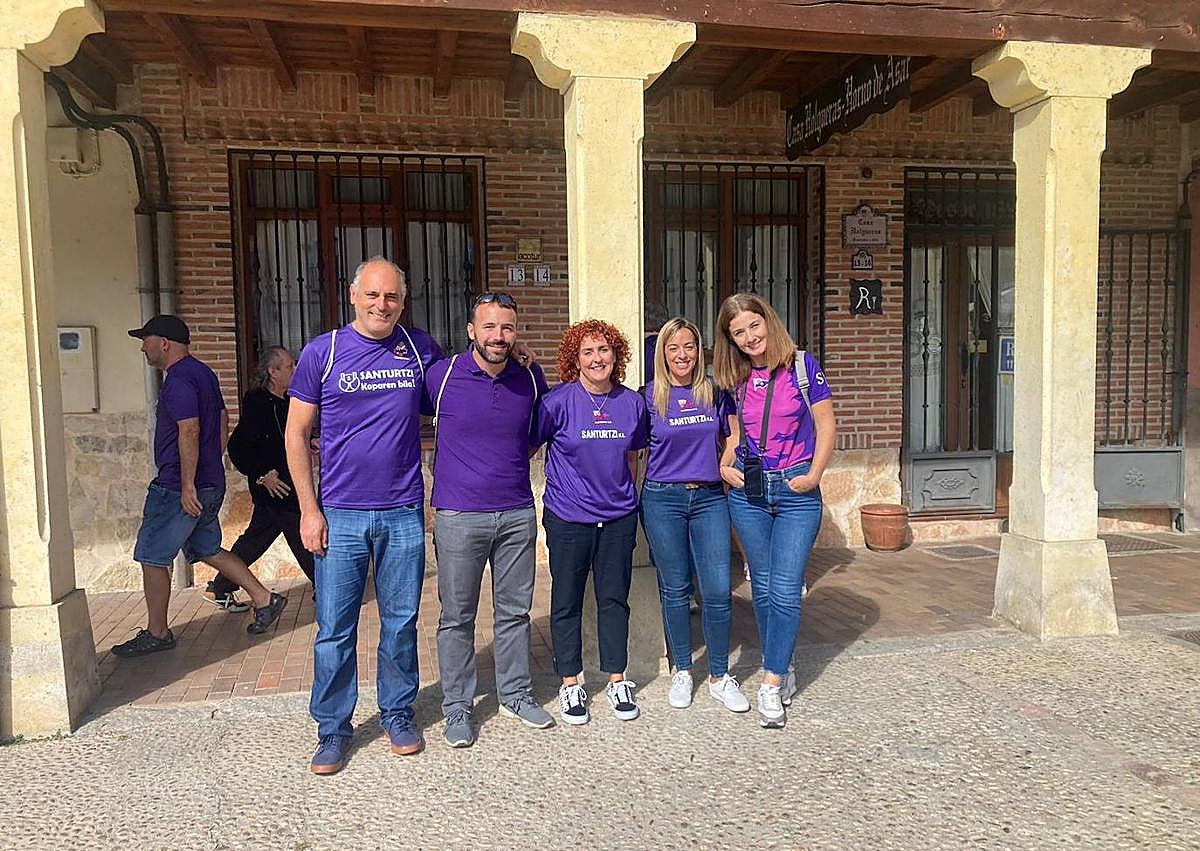 Imagen secundaria 1 - Arriba, los jugadores del Santurtzi y aficionados morados en Turégano. A la izquierda, la alcaldesa, Karmele Tubilla (en el centro), junto al exalcalde Ricardo Iriarte (primero por la izquierda) y tres concejales. A la derecha, Arantxa Legido y Gorka Fernández, delante del castillo de Turégano.