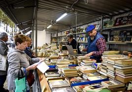 Una mujer consulta a Josu Mazas, de Librobilbao, la lista de libros que lleva apuntados.