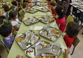 Alumnos toman el almuerzo en un comedor escolar.