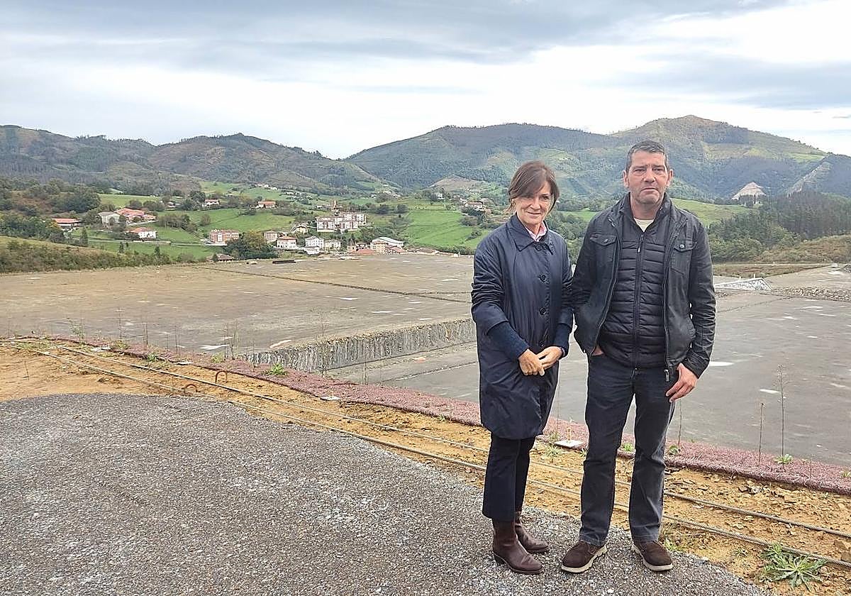 La presidenta de la S.D. Eibar y el alcalde de Mallabia posan frente al solar del futuro espacio deportivo.