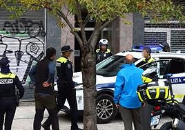 Policías locales introducen en un coche patrulla a uno de los ladrones pillados ayer, viernes, en un piso de Coronación.