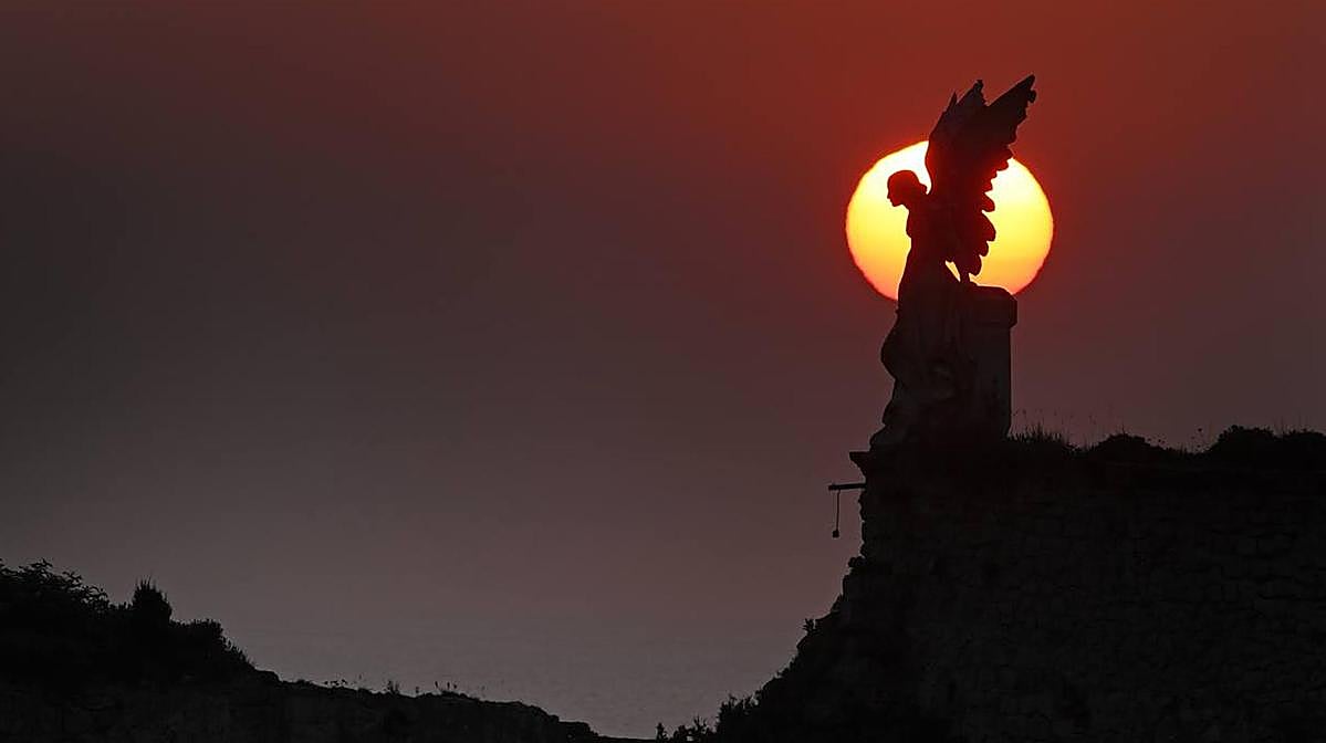 Atardercer en el cementerio de Comillas con la escultura de 'El ángel exterminador' de Josep Limona (1895)