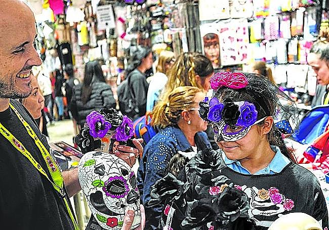 Una jóven se prueba disfraces en una tienda del centro de Bilbao.
