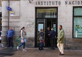 Usuarios consultan en la puerta del Instituto Nacional de Seguridad Social en la calle Dato.