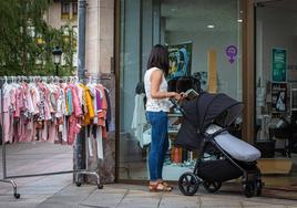 Una mujer mira ropa de niño en un comercio de Gernika.