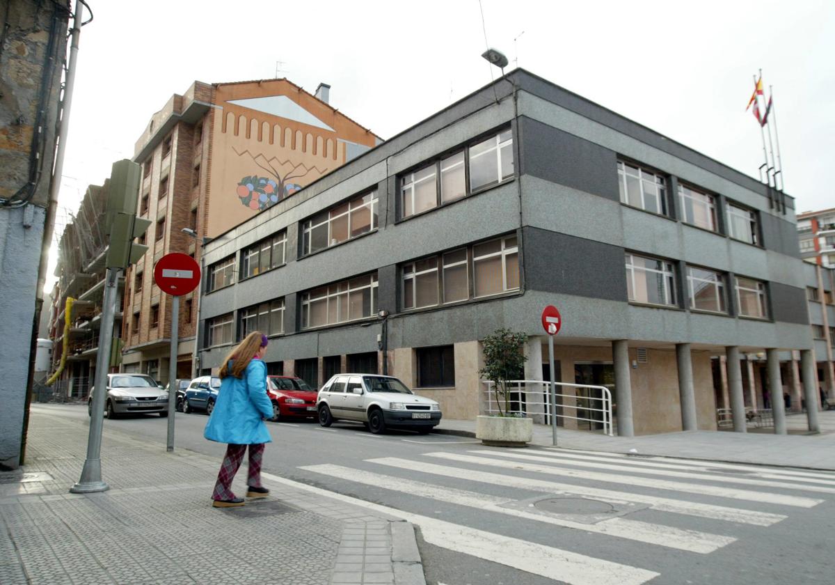 Una persona cruza un paso de cebra junto al Ayuntamiento.