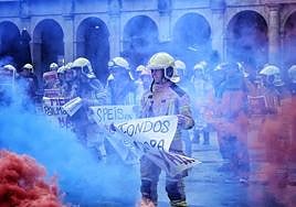 Un bombero con una pancarta durante la concentración frente al Ayuntamiento de Vitoria.