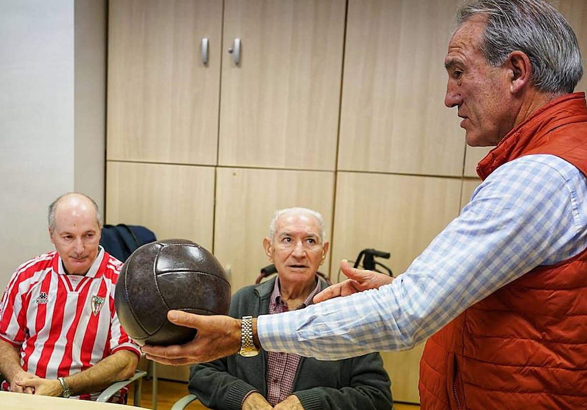 Andoni Goikoetxea, con un balón antiguo, se dirige a Diosdado y José.