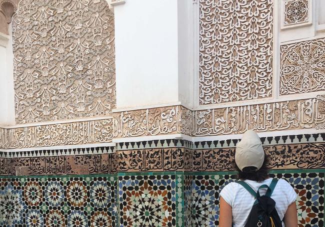 Una turista admira la decoración en la Medersa Ben Youssef.