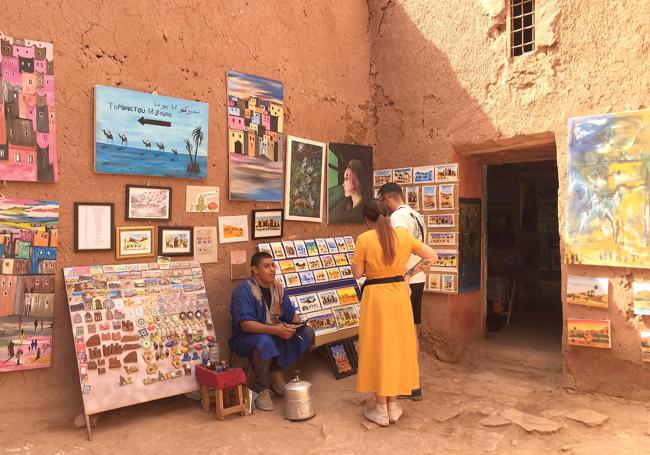 Dos turistas compran una obra a un artista callejero.