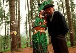 Agustín Ibarrola posa junto a uno de los árboles que los radicales intentaron derribar en el bosque de Oma.