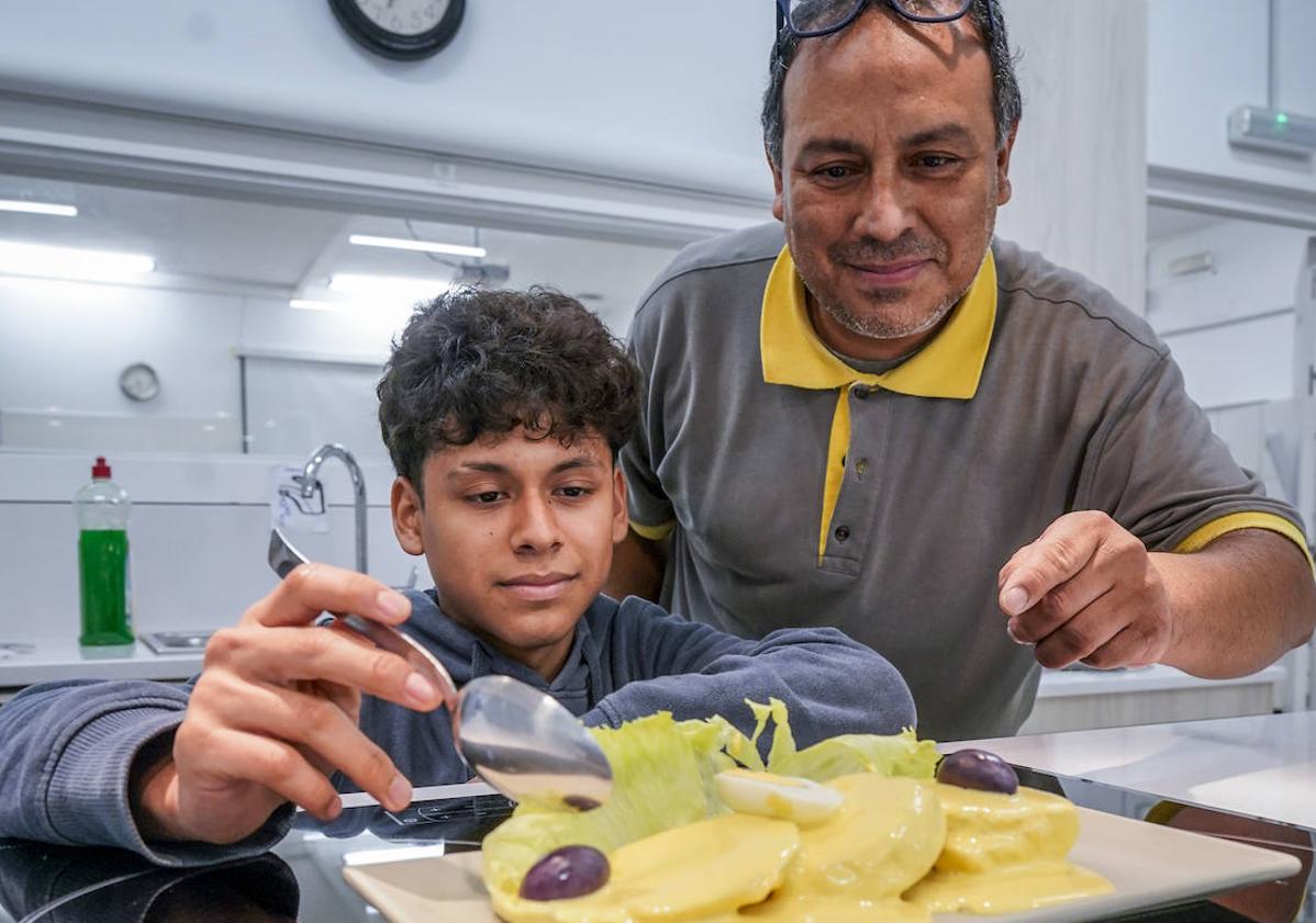 Imagen principal - En la foto superior, Xavier Gabriel Gonzáles junto a su padre, Javier Gabriel. En la parte inferior, Abril observa a su amiga Angelina que sirve una copa de chicha venezolana.