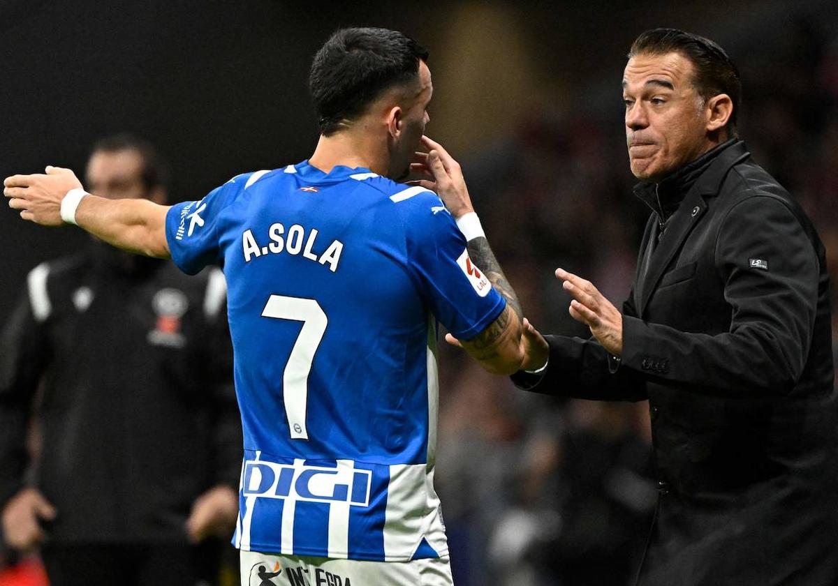 Álex Sola dialoga con Luis García durante el partido ante el Atlético en el Metropolitano.