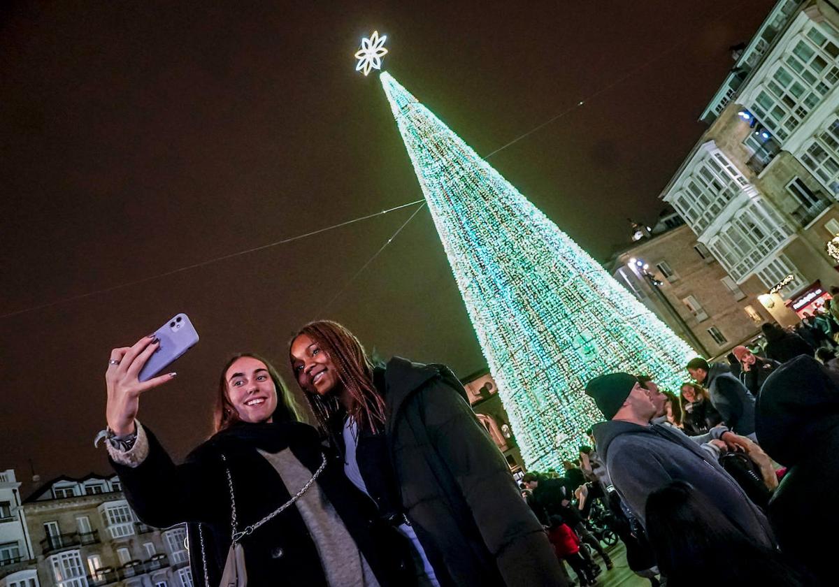 Naroa y Sarah, dos amigas con el espíritu navideño subidísimo, a los pies del gigantesco abeto iluminado en la Virgen Blanca.