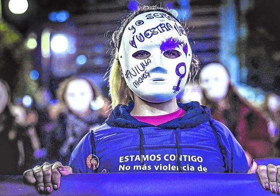 Una mujer enmascarada llora por las víctimas en el Día Internacional de la Eliminación de la Violencia Contra la Mujer.