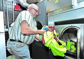 Dionisio Humara, presidente del Cayón, saca la ropa de los jugadores de la lavadora antes de ponerla a secar, una de sus muchas tareas.