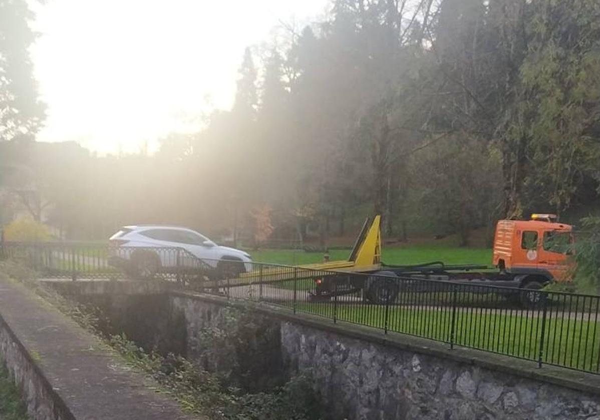 El coche accidentado sale de las escaleras con la ayuda de una grúa.