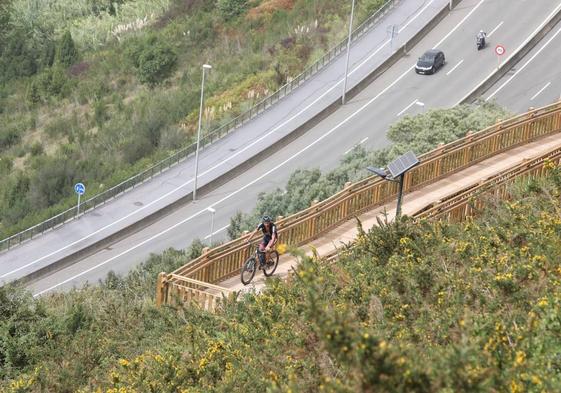 Un ciclista sube a Artxanda por la nueva pasarela de madera.