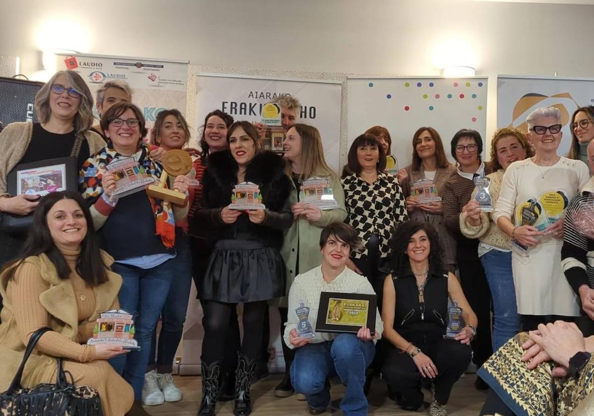 Imagen principal - Foto de familia en la entrega de premios y de los escaparates de la carnicería Burrutxaga de Amurrio y del restaurante La Encina en Artziniega.