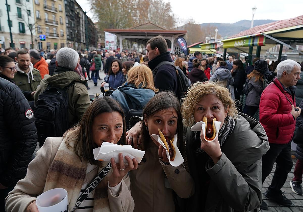 Tres asistentes a la feria no se han resistido a degustar el típico talo con chorizo, que se puede comprar por entre 6,50 y 7 euros.