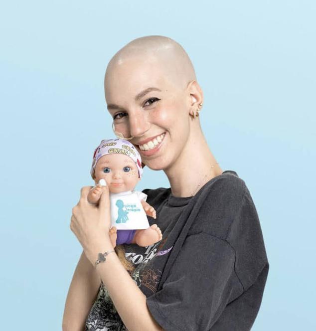 Con su baby pelona solidaria de Juegaterapia. El pañuelo fue diseñado y dibujado por ella misma, con el lema: «Mis ganas ganan».