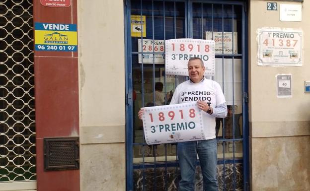 El lotero de Alzira, con el cartel del tercer premio. 