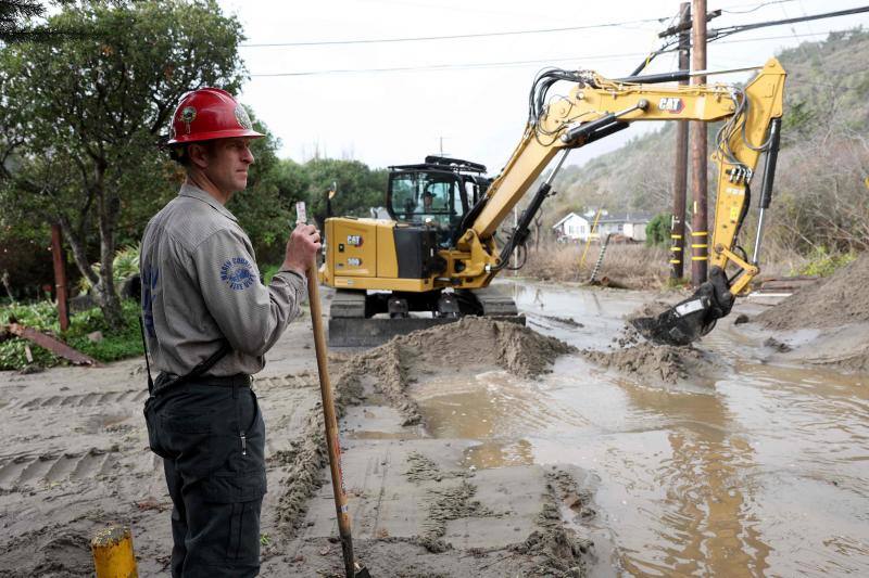 Servicios de emergencia tratan de retirar el barro y el agua en la comunidad Stinson Beach, al norte de California.