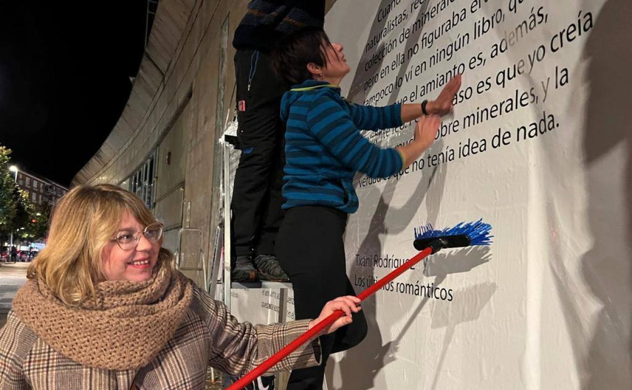 Txani Rodríguez, colocando el mural con un fragmento de su obra. 