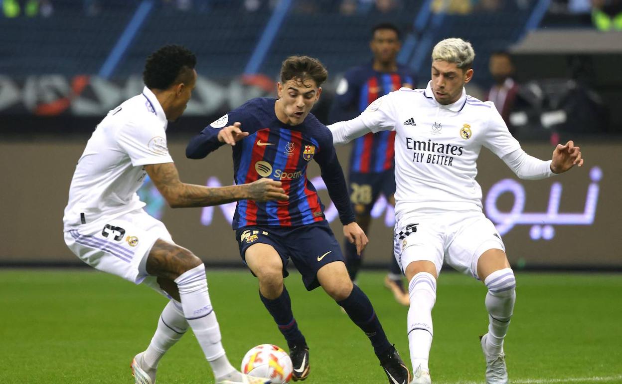 Militao y Valverde intentan frenar la progresión del barcelonista Gavi. 