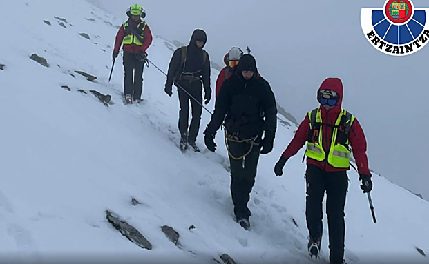 Miembros de la Ertzaintza acompañan encordados a los dos jóvenes montañeros. 