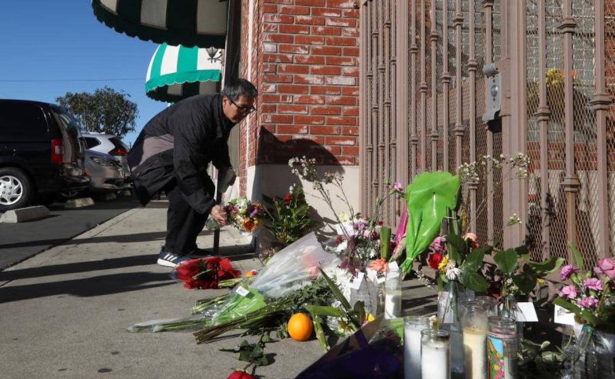 Un hombre enciende una vela en la entrada del Star Ballroom Dance Studio después del tiroteo masivo durante las celebraciones del Año Nuevo Lunar Chino en Monterey Park, California. 