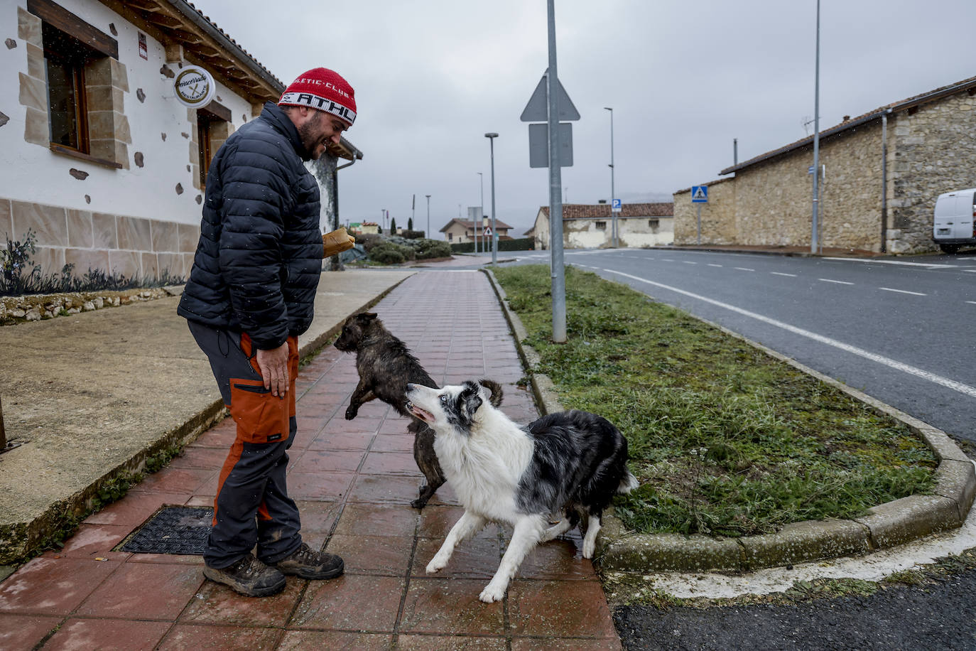 Un hombre juguetea con sus perros en la zona de Herrera.